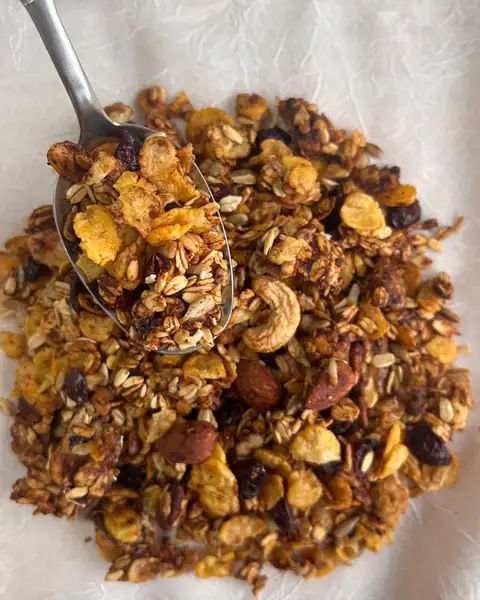 Cuchara con granola horneada de avena, copos, castañas de cajú y arándanos